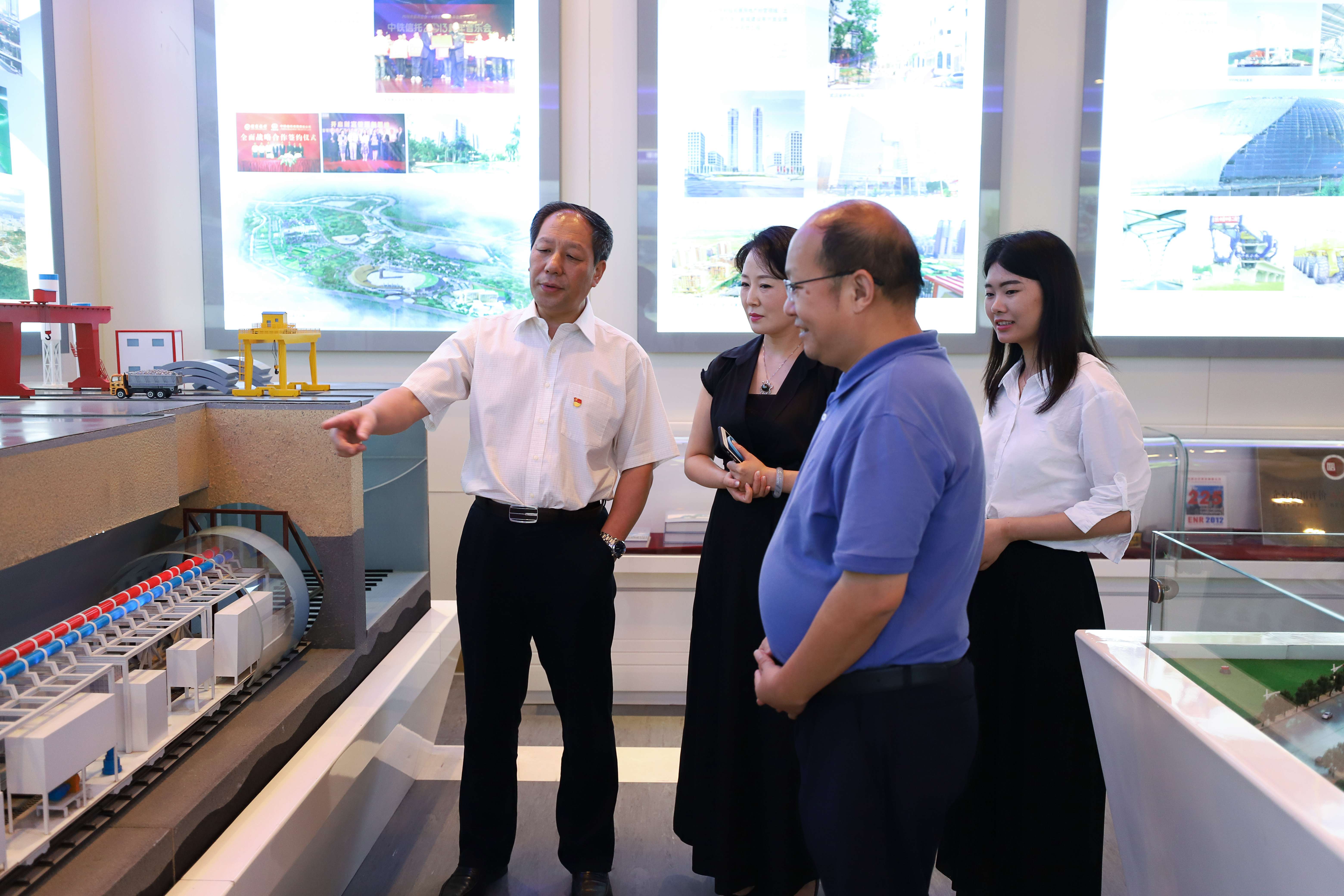 中國(guó)中鐵董秘何文（左一）向《證券日?qǐng)?bào)》記者介紹中鐵盾構(gòu)模型。（圖片來源：證券日?qǐng)?bào)）.jpg